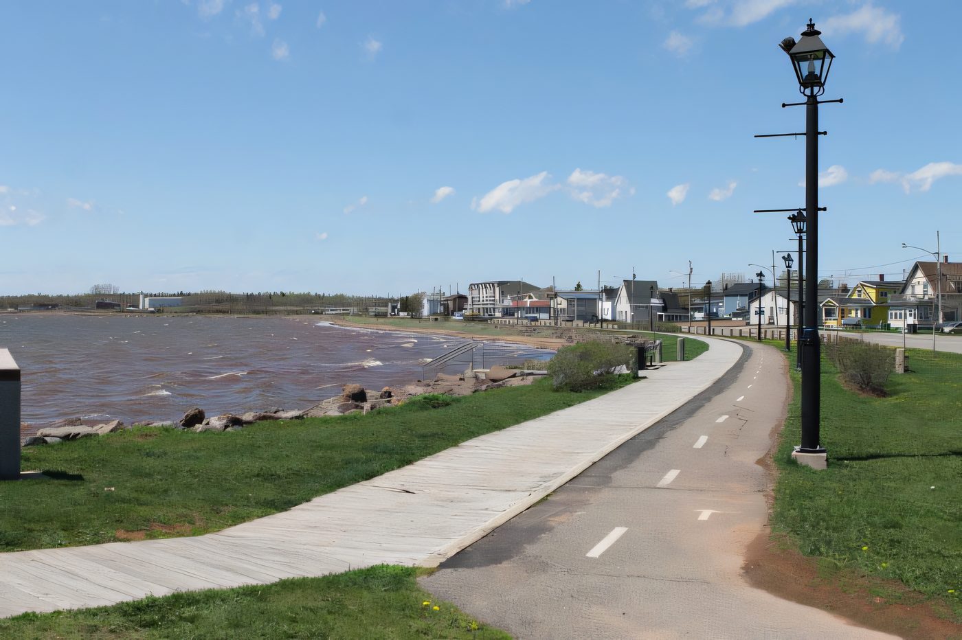 The boardwalk curving along the Summerside shoreline, lamp posts every few metres, the bay on the left